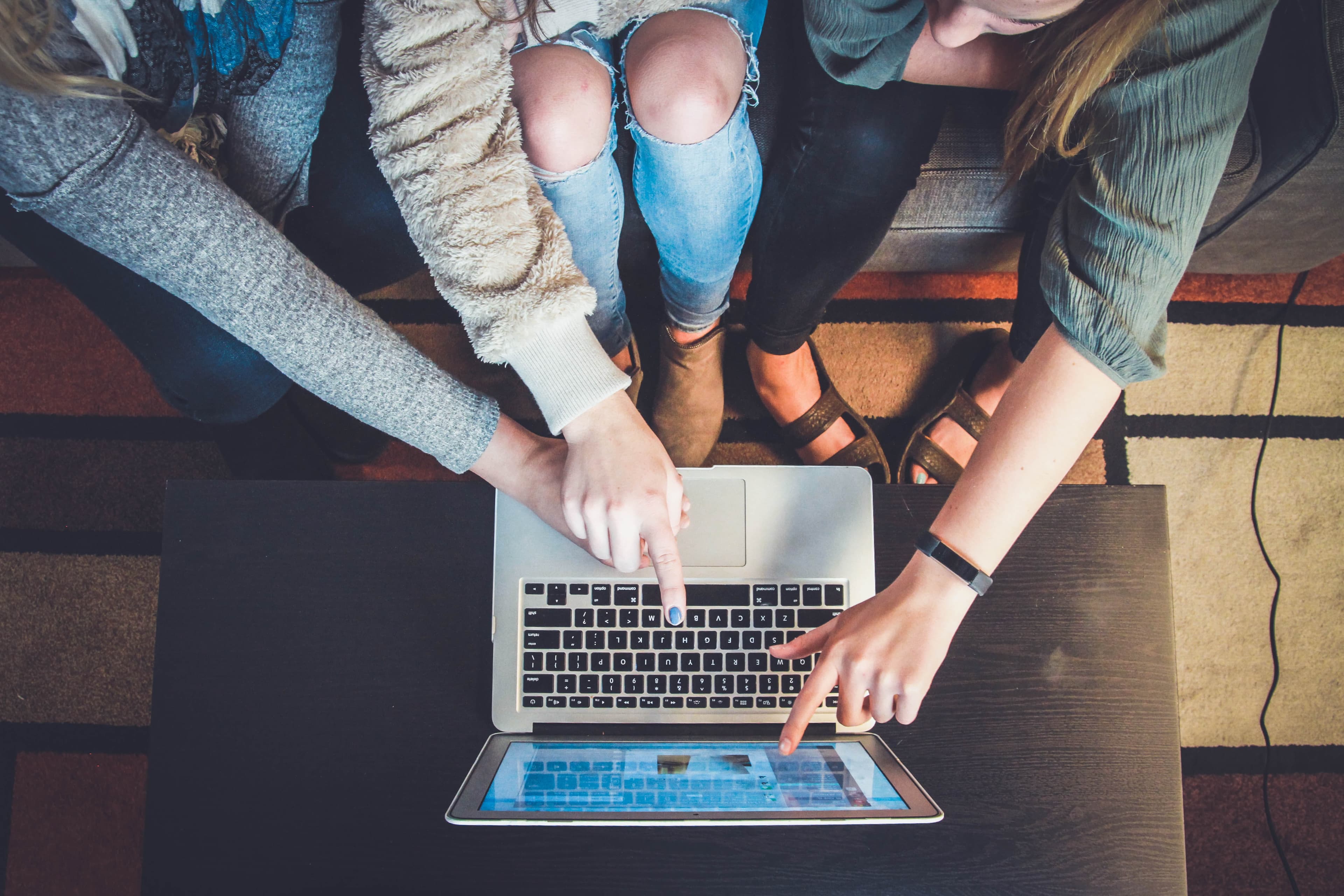 Three people looking at a laptop