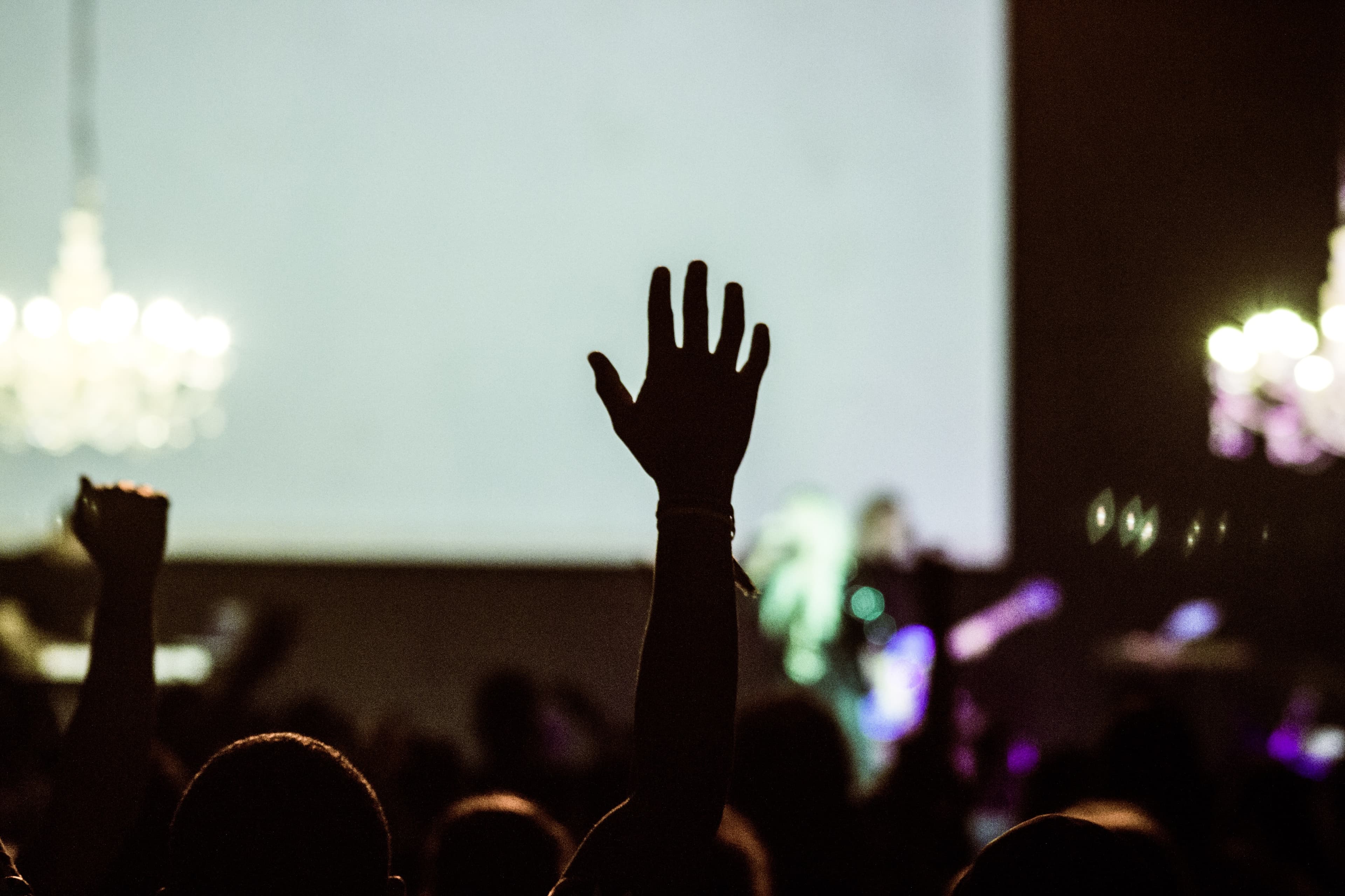 Large audience with person raising hand to ask a question