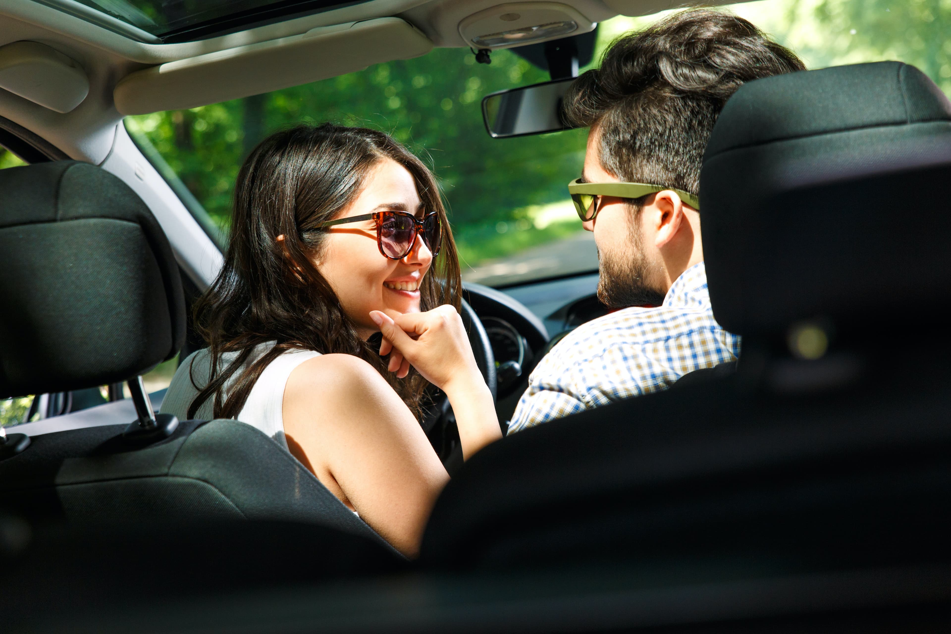 Woman and man driving away in car